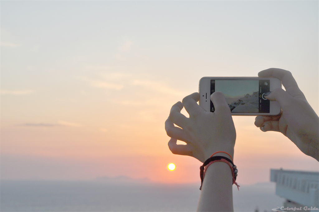 smartphone hands sunset sea santorini