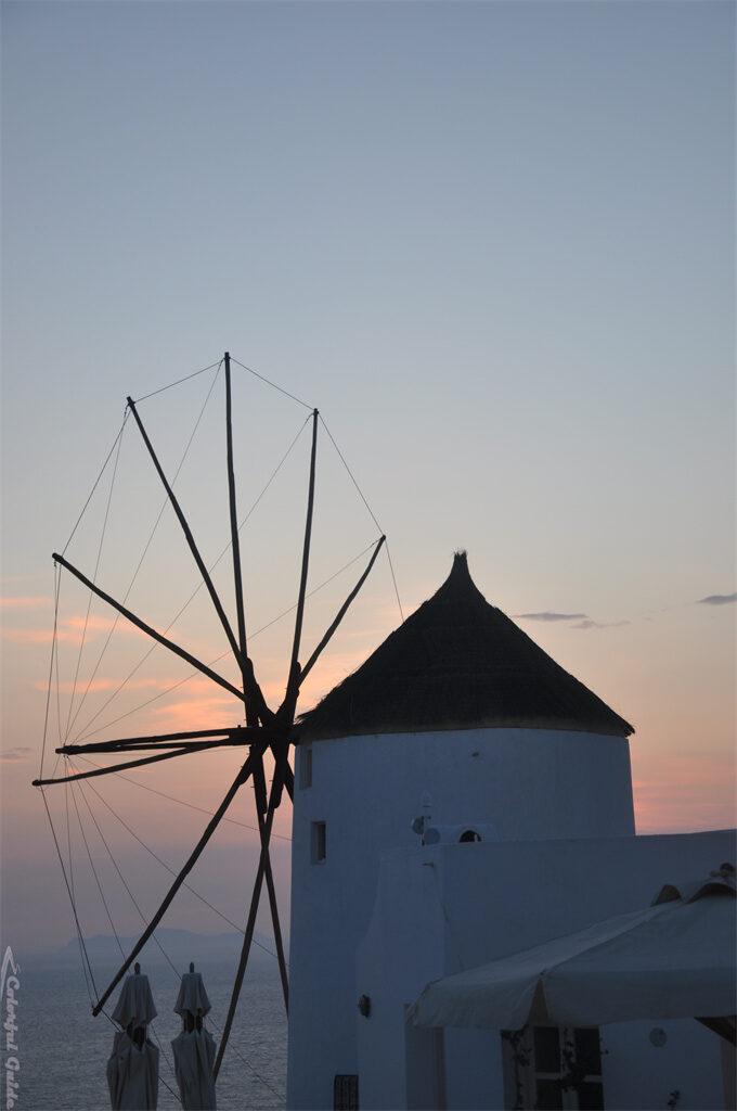 windmill umbrella sunset oia greece rotated